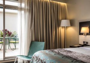 a bedroom with a bed and a table and a window at Eka Hotel Nairobi in Nairobi