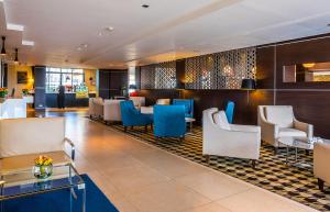 a lobby of a hotel with blue chairs and tables at Eka Hotel Nairobi in Nairobi