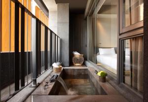 un bagno con un lavandino e un letto in una stanza di 礁溪晶泉丰旅 Wellspring by Silks Jiaoxi a Jiaoxi