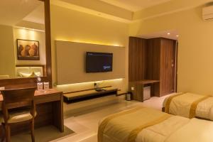 pokój hotelowy z 2 łóżkami i telewizorem z płaskim ekranem w obiekcie Sangai Continental (The Boutique Hotel) w mieście Imphal