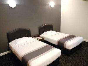 2 bedden in een hotelkamer met 2 slaapkamers bij Greenlast Hotel in Kuantan