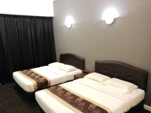twee bedden in een hotelkamer met bij Greenlast Hotel in Kuantan