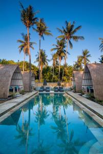 una piscina resort con palmeras en el fondo en Gili Meno Escape - Adults Only en Gili Meno
