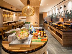 un restaurant avec un buffet composé de plats et de boissons dans l'établissement Super Hotel Tokyo Shiba, à Tokyo