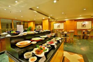 a buffet line with plates of food in a restaurant at Gokulam Park in Cochin