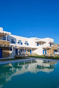 a house with a swimming pool in front of a building at Villa Del Sol Mykonos in Ornos