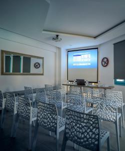 a room with chairs and a screen with a presentation at Nikolas Hotel in Karterados