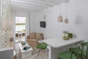 a white living room with a couch and a table at Villa Del Sol Mykonos in Ornos