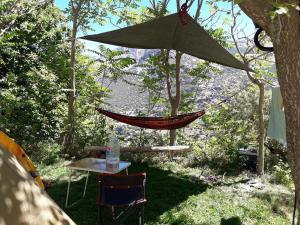 uma rede de descanso e uma mesa e cadeiras num quintal em Bungalow Camping Trevélez em Trevélez