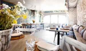 ein Restaurant mit Tischen und Stühlen und einem großen Fenster in der Unterkunft Hostal Sa Tuna in Begur