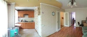 a kitchen with wooden cabinets and a tv in a room at Two-bedroom apartment on Lenina avenue in Mykolaiv