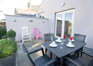 a patio with a table with two glasses of wine at RossNua in Rosscarbery
