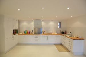 a kitchen with white cabinets and wooden counter tops at Chalet Utopia in Valberg