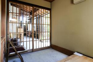 an empty room with a door to a room with a window at Konuka Yakushi Temple House in Kyoto