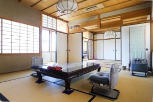 a dining room with a glass table and chairs at Konuka Yakushi Temple House in Kyoto