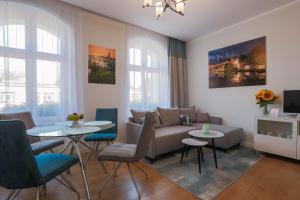 salon z kanapą, stołem i krzesłami w obiekcie Proseco Apartments -Self check-in- w mieście Opole