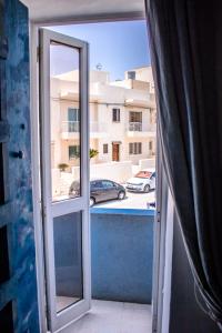 eine offene Tür zu einem Balkon mit Blick auf ein Gebäude in der Unterkunft Hostel Malti Budget in St Julian's