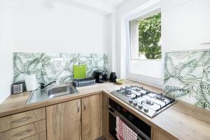 a kitchen with a stove top oven next to a window at Apartament Smętka in Olsztyn