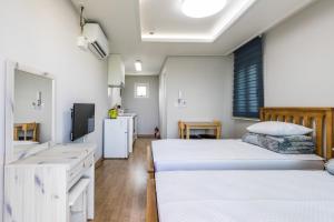 a hospital room with two beds and a tv at Jeju Bada Wi Olle Pension in Seogwipo