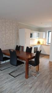 a dining room table with chairs and a kitchen at FeWo an der Ostsee Nr. 5 in Rerik