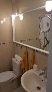 een badkamer met een toilet, een wastafel en een spiegel bij Las Algas 1 Etage in Maspalomas