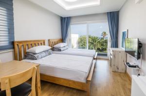 1 dormitorio con 1 cama y 1 mesa en Jeju Bada Wi Olle Pension, en Seogwipo