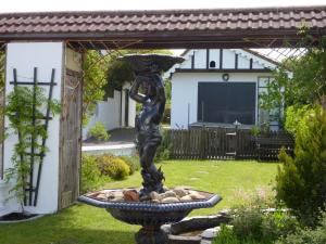 uma estátua de uma mulher segurando um guarda-chuva em um jardim em Banfield Lodge for Gower em Swansea