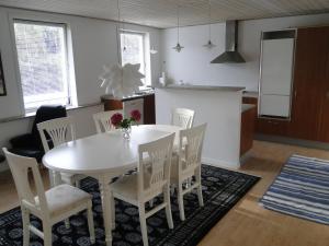 una cucina e una sala da pranzo con tavolo e sedie bianchi di Thinghuskroen a Vestervig