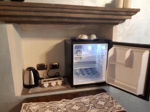 a small refrigerator with its door open in a kitchen at Suite La Gioconda in Castiglion Fiorentino