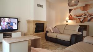 un salon avec un canapé et une télévision dans l'établissement Les Prairies de l'Encrême, à Céreste