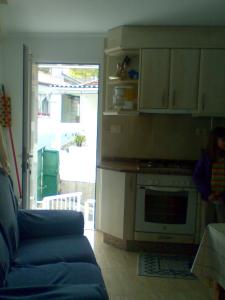 a living room with a blue couch and a kitchen at Casa de la Abuela in Bubaces