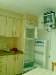 a kitchen with a refrigerator and a tv on the wall at Casa de la Abuela in Bubaces