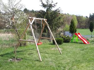 a swing set in a yard with a playground at Ferienhaus Wunderland in Kirchenbruch