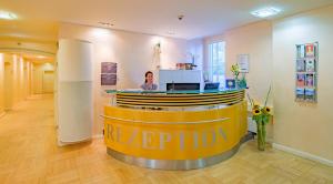 a woman sitting at a reception desk in a lobby at XII Apostel Albergo in Cologne