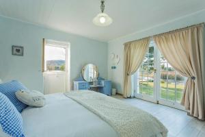 a bedroom with a bed and a large window at Shanzeley Guest House in George