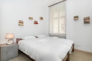 biała sypialnia z łóżkiem i oknem w obiekcie Apartments Poznań Strzałowa by Noclegi Renters w Poznaniu