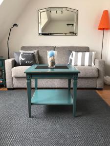 einen blauen Couchtisch im Wohnzimmer mit Sofa in der Unterkunft Kastanienhüs Apartment in Westerland