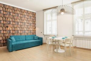 salon z niebieską kanapą i stołem w obiekcie Apartments Poznań Strzałowa by Noclegi Renters w Poznaniu