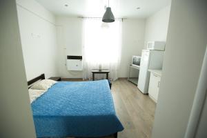 リヴィウにあるАпартаменти-студія по вул.Дудаєва 19/8аの小さなベッドルーム(青いベッド1台付)、キッチンが備わります。