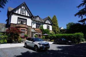 two cars parked in front of a house at Dene House Guest House in Bowness-on-Windermere