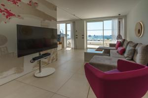 a living room with a couch and a tv at One Ibiza Suites in Ibiza Town