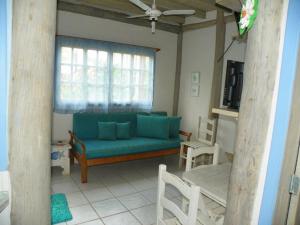 a living room with a blue couch and chairs at Chalés Musa de Maresias in Maresias