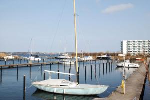 a sail boat docked at a dock with other boats at Freiwasser Appartment in Glücksburg
