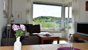 a living room with a couch and a vase with flowers at Freiwasser Appartment für 2 Personen in Glücksburg