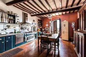 a kitchen with blue cabinets and a table in it at The Artists' Tower in San Gimignano