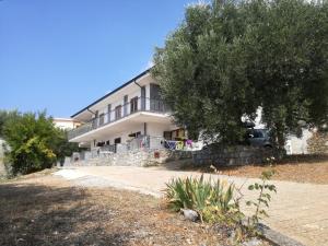 una casa grande con un árbol delante en Appartamenti La Chiandata, en Marina di Camerota