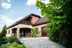 a house with a stone driveway in front of it at Vándor Fogadó in Gyöngyössolymos