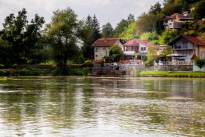 un groupe de maisons sur les rives d'une rivière dans l'établissement Villa Dino, à Kulen Vakuf