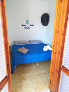 トッレ・デル・オルソにあるCamera Torre Dell'Orsoの青いベッドが備わる小さな客室です。