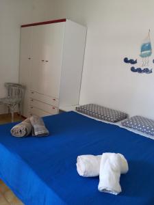 Dos toallas sentadas en una cama azul en una habitación en Camera Torre Dell'Orso, en Torre dell'Orso